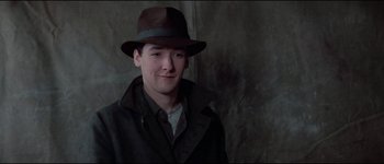 Movie still from “The Journey of Natty Gann” (1985), directed by Jeremy Kagan – A young man wearing a brown hat and a brown jacket; Close Up shot, Low angle