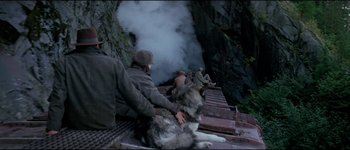 Movie still from “The Journey of Natty Gann” (1985), directed by Jeremy Kagan – A group of people sitting on a dock with a dog; Wide shot, High angle