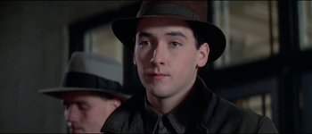 Movie still from “The Journey of Natty Gann” (1985), directed by Jeremy Kagan – A young man wearing a hat and a jacket; Close Up shot, Low angle