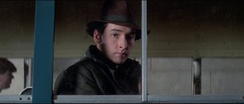 Movie still from “The Journey of Natty Gann” (1985), directed by Jeremy Kagan – A young man wearing a hat looking out of a window; Close Up shot, Low angle