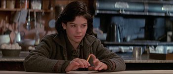 Movie still from “The Journey of Natty Gann” (1985), directed by Jeremy Kagan – A young girl writing on a piece of paper with a pencil; Close Up shot, High angle