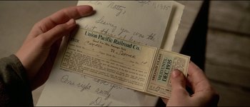 Movie still from “The Journey of Natty Gann” (1985), directed by Jeremy Kagan – A person holding a train ticket in their hand; Extreme Close Up shot, Overhead angle