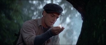 Movie still from “The Journey of Natty Gann” (1985), directed by Jeremy Kagan – A man holding a lit match in his hand; Close Up shot, Low angle