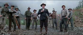 Movie still from “The Journey of Natty Gann” (1985), directed by Jeremy Kagan – A group of men standing on top of a rocky ground; Medium shot, Low angle