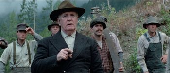 Movie still from “The Journey of Natty Gann” (1985), directed by Jeremy Kagan – A group of men standing next to each other in a forest; Medium shot, Low angle