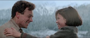 Movie still from “The Journey of Natty Gann” (1985), directed by Jeremy Kagan – A man and a woman smiling at each other; Close Up shot, Over the shoulder angle