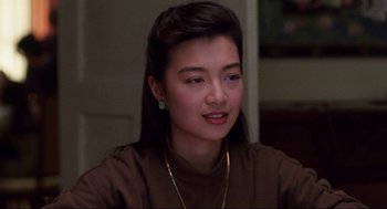 Movie still from “The Joy Luck Club” (1993), directed by Wayne Wang – A young woman with long dark brown hair wearing a brown shirt; Close Up shot, Over the shoulder angle