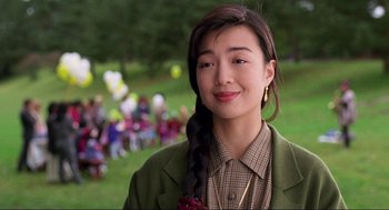 Movie still from “The Joy Luck Club” (1993), directed by Wayne Wang – A woman with a braid in front of a group of people; Close Up shot, Over the shoulder angle