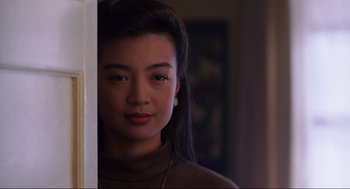 Movie still from “The Joy Luck Club” (1993), directed by Wayne Wang – A young woman with long black hair standing in front of a door; Close Up shot, Over the shoulder angle