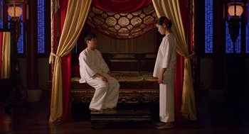 Movie still from “The Joy Luck Club” (1993), directed by Wayne Wang – A man and a woman are sitting on a bed; Wide shot, High angle