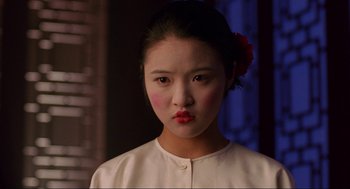 Movie still from “The Joy Luck Club” (1993), directed by Wayne Wang – A young woman with red lipstick looking at the camera; Close Up shot, Over the shoulder angle