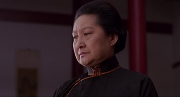 Movie still from “The Joy Luck Club” (1993), directed by Wayne Wang – An older asian woman in a black dress looking sad; Close Up shot, Low angle