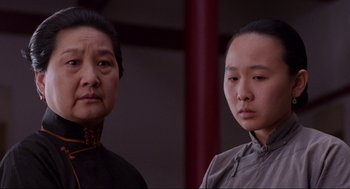 Movie still from “The Joy Luck Club” (1993), directed by Wayne Wang – Two women standing next to each other in front of a wall; Close Up shot, Low angle
