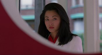 Movie still from “The Joy Luck Club” (1993), directed by Wayne Wang – A beautiful young woman looking at the camera in front of a mirror; Close Up shot, Over the shoulder angle