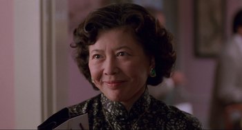 Movie still from “The Joy Luck Club” (1993), directed by Wayne Wang – An older asian woman wearing a black and white dress; Close Up shot, Low angle