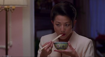 Movie still from “The Joy Luck Club” (1993), directed by Wayne Wang – A woman eating a bowl of food with chopsticks in her mouth; Close Up shot, High angle