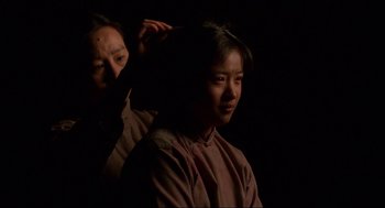 Movie still from “The Joy Luck Club” (1993), directed by Wayne Wang – A woman getting her hair combed by another woman; Close Up shot, Over the shoulder angle