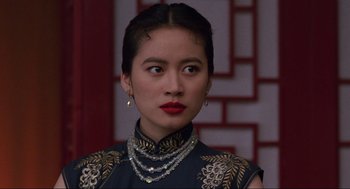 Movie still from “The Joy Luck Club” (1993), directed by Wayne Wang – A woman wearing a black and gold dress and wearing a necklace; Close Up shot, Over the shoulder angle