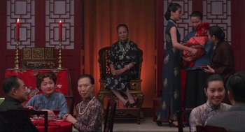 Movie still from “The Joy Luck Club” (1993), directed by Wayne Wang – A group of people sitting in a room with candles; Medium shot, Over the shoulder angle