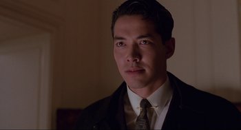 Movie still from “The Joy Luck Club” (1993), directed by Wayne Wang – A man wearing a suit and tie in a dark room; Close Up shot, Low angle