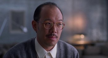 Movie still from “The Joy Luck Club” (1993), directed by Wayne Wang – A person wearing glasses and a tie; Close Up shot, Low angle