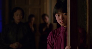 Movie still from “The Joy Luck Club” (1993), directed by Wayne Wang – A young girl standing in front of two other people; Close Up shot, Over the shoulder angle