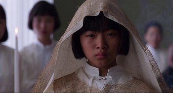 Movie still from “The Joy Luck Club” (1993), directed by Wayne Wang – A young asian girl wearing a white dress and a white hat; Close Up shot, Low angle