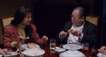 Movie still from “The Joy Luck Club” (1993), directed by Wayne Wang – A man and a woman sitting at a dinner table; Medium shot, High angle