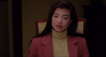 Movie still from “The Joy Luck Club” (1993), directed by Wayne Wang – A woman sitting in a chair wearing a red jacket; Close Up shot, High angle