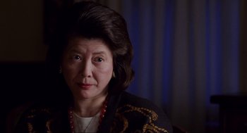 Movie still from “The Joy Luck Club” (1993), directed by Wayne Wang – An older woman wearing a black jacket and a red necklace; Close Up shot, Over the shoulder angle
