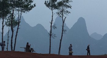 Movie still from “The Joy Luck Club” (1993), directed by Wayne Wang – Two people are sitting on a bench near a tree; Extreme Wide shot, Over the shoulder angle