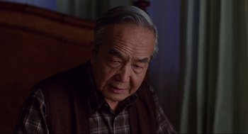 Movie still from “The Joy Luck Club” (1993), directed by Wayne Wang – An older man sitting in front of a window; Close Up shot, Over the shoulder angle