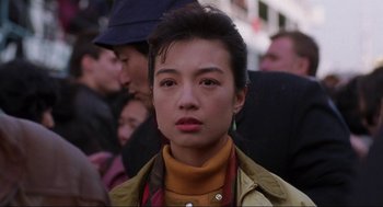 Movie still from “The Joy Luck Club” (1993), directed by Wayne Wang – A young woman with short black hair wearing a yellow jacket; Close Up shot, Over the shoulder angle