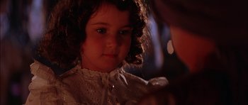 Movie still from “The Jungle Book” (1994), directed by Stephen Sommers – A little girl in a white dress looking at the camera; Close Up shot, Over the shoulder angle