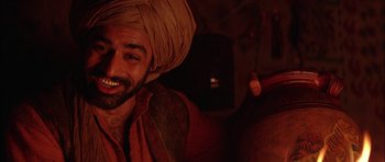 Movie still from “The Jungle Book” (1994), directed by Stephen Sommers – A man with a beard and a turban is smiling for the camera; Close Up shot, Over the shoulder angle