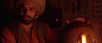 Movie still from “The Jungle Book” (1994), directed by Stephen Sommers – A man with a beard and a turban is holding a carrot; Close Up shot, Over the shoulder angle