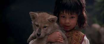 Movie still from “The Jungle Book” (1994), directed by Stephen Sommers – A little girl is holding a small puppy; Close Up shot, High angle