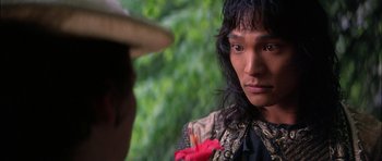 Movie still from “The Jungle Book” (1994), directed by Stephen Sommers – A man with a hat and a flower in his mouth; Close Up shot, Over the shoulder angle