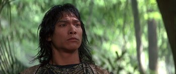 Movie still from “The Jungle Book” (1994), directed by Stephen Sommers – A man with long black hair is looking into the distance; Close Up shot, Low angle