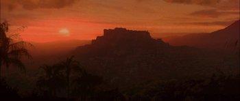 Movie still from “The Jungle Book” (1994), directed by Stephen Sommers – The sun is setting over a mountain with a castle on top of it; Extreme Wide shot, Low angle