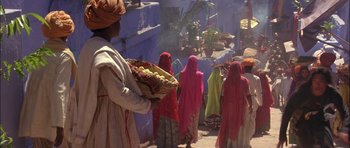 Movie still from “The Jungle Book” (1994), directed by Stephen Sommers – A group of women walking down a street; Wide shot, Over the shoulder angle