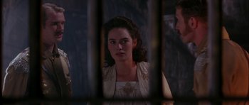 Movie still from “The Jungle Book” (1994), directed by Stephen Sommers – A woman in a white dress looking through a fence; Close Up shot, Over the shoulder angle