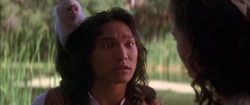 Movie still from “The Jungle Book” (1994), directed by Stephen Sommers – A man with long black hair is looking at the camera; Close Up shot, Over the shoulder angle