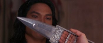 Movie still from “The Jungle Book” (1994), directed by Stephen Sommers – A man holding a knife in front of his face; Close Up shot, Over the shoulder angle