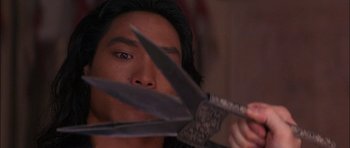 Movie still from “The Jungle Book” (1994), directed by Stephen Sommers – A man holding a pair of scissors in front of his face; Extreme Close Up shot, High angle