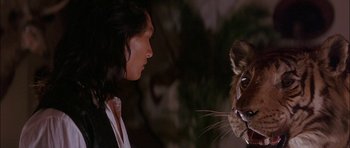 Movie still from “The Jungle Book” (1994), directed by Stephen Sommers – A man and a tiger face to face in the dark; Close Up shot, Over the shoulder angle