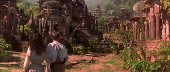 Movie still from “The Jungle Book” (1994), directed by Stephen Sommers – A man standing in front of a bunch of buildings; Extreme Wide shot, High angle