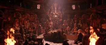 Movie still from “The Jungle Book” (1994), directed by Stephen Sommers – A group of people standing in a room with statues on the wall; Extreme Wide shot, High angle