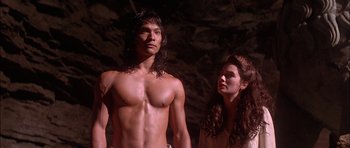 Movie still from “The Jungle Book” (1994), directed by Stephen Sommers – A man and a woman standing next to each other in a cave; Medium shot, Low angle