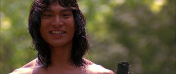 Movie still from “The Jungle Book” (1994), directed by Stephen Sommers – A man with long black hair smiling for the camera; Close Up shot, Low angle
